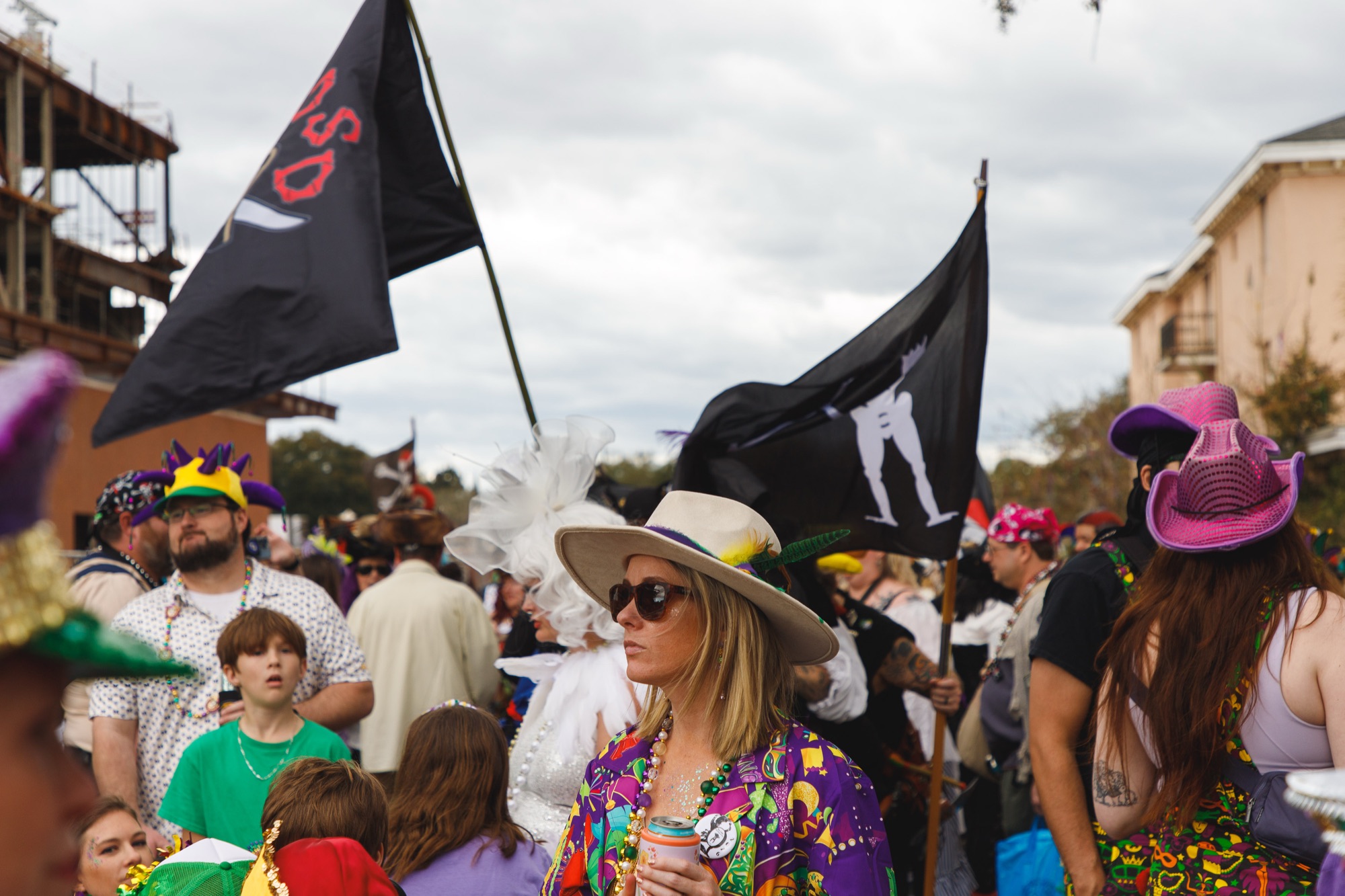 Joe Cain Day crowd with black krewe flags flying overhead